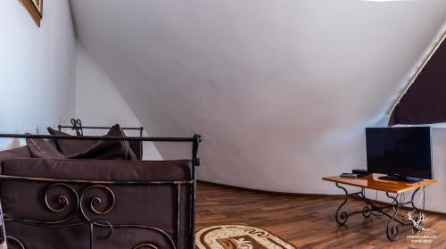 a room with a bed and a table with a television at Pensiunea LIN COTA 1000 in Sinaia