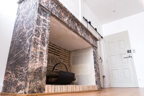 a fireplace made out of stone in a living room at LE BAS CHITRAY in Ménil