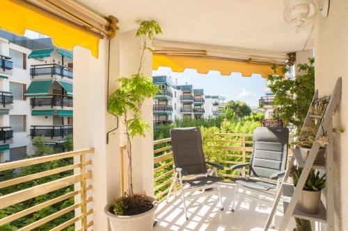 a balcony with two chairs and a view of some buildings at L'Eixideta in Salou