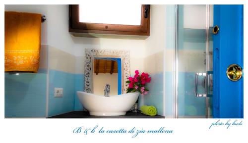 a bathroom with a white sink and a mirror at La casetta in Dorgali