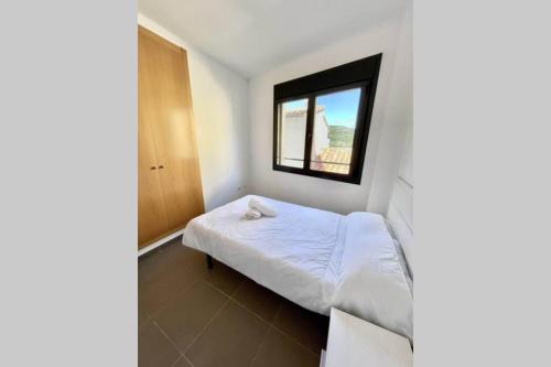 a small bedroom with a bed and a window at APTO LOS MOLINOS LUCENA DEL CID Bajo C REF 048 in Lucena del Cid