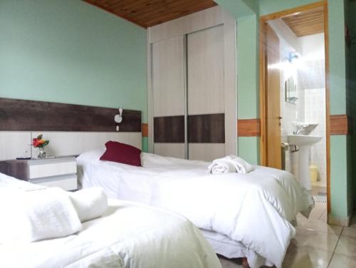 a bedroom with two beds with white sheets at Departamentos Paisaje del Beagle in Ushuaia