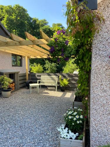 a patio with a bench and some plants and flowers at Ridgewood Apartment in Drumnadrochit