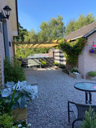 a patio with a table and chairs and a fence at Ridgewood Apartment in Drumnadrochit