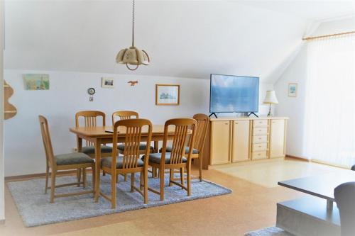 ein Esszimmer mit Tisch und Stühlen und einem Fernseher in der Unterkunft FeWo-Norden in Norden