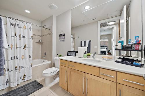 a bathroom with a sink and a toilet and a mirror at Corporate rental unit City Centre, Energy Corridor in Houston