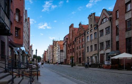 an empty street in an old city with buildings at Apartament przy Ścieżce Kościelnej in Elblag
