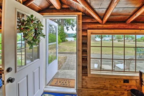 an open door in a log home with windows at Historic Belfair Cabin Abode on the Hood Canal! in Belfair