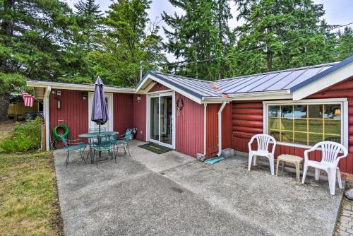 a red house with a patio and a table and chairs at Historic Belfair Cabin Abode on the Hood Canal! in Belfair
