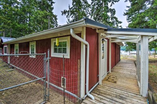 a red house with a porch on a wooden deck at Historic Belfair Cabin Abode on the Hood Canal! in Belfair