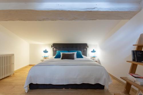 une chambre avec un grand lit avec des oreillers bleus dans l'établissement Duplex Flamingo, l'Hauture, Arles, à Arles