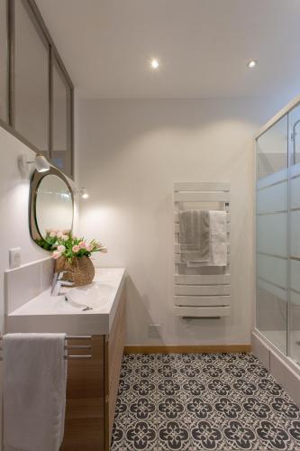 une salle de bain avec un lavabo et un miroir dans l'établissement Duplex Flamingo, l'Hauture, Arles, à Arles