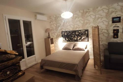 1 dormitorio con 1 cama, 1 sofá y 1 lámpara en Trés beau studio 35 M2 Entre Mer et Forêt grand jardin et douche tropicale, en La Seyne-sur-Mer