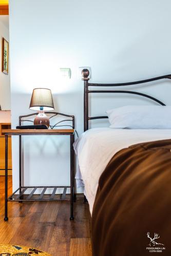 a bedroom with a bed and a lamp on a night stand at Pensiunea LIN COTA 1000 in Sinaia