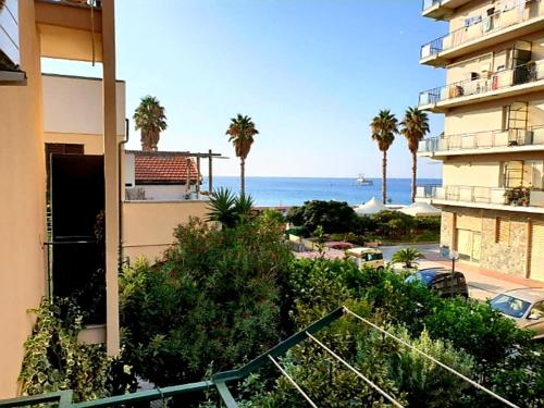 - une vue sur l'océan depuis un bâtiment avec des palmiers dans l'établissement RAFFAELLO Beach Apartment - 50 m from the sea - WIFI, à Savone