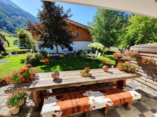a wooden table with flowers on a patio at Aquarell Apartments in Saas-Grund