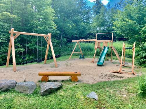 a playground with two swings and a slide at Le Boisé (Les Manoirs) Mont-Tremblant in Mont-Tremblant
