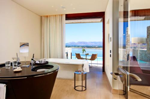 a bathroom with a bath tub and a large window at Nafplia Palace Hotel & Villas in Nafplio