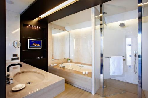 a bathroom with a large tub and a sink at Nafplia Palace Hotel & Villas in Nafplio