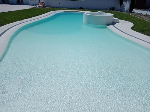 a swimming pool with blue water in a yard at Apartamento, wi-fI, terrasse in Vagos