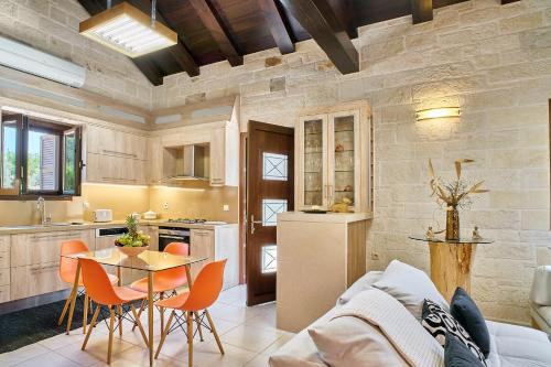kuchnia i salon ze stołem i krzesłami w obiekcie Aktis luxury villa w Chanii