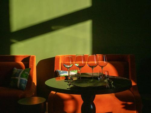 a table with four wine glasses on it at Hôtel Maison Pavlov in Le Bouscat