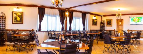 a restaurant with tables and chairs in a room at Pensiunea LIN COTA 1000 in Sinaia