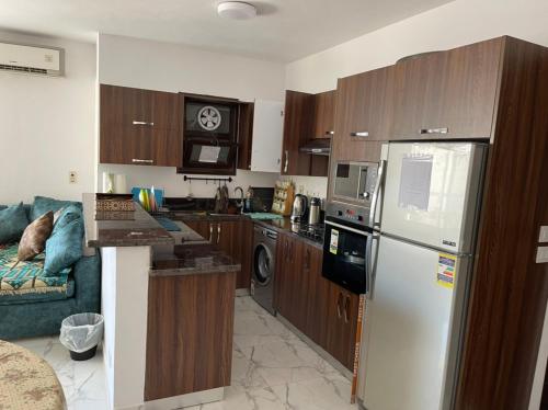 a kitchen with wooden cabinets and a white refrigerator at شقة غرفتين وصاله- بورتوسعيد Porto Said Resort in Port Said