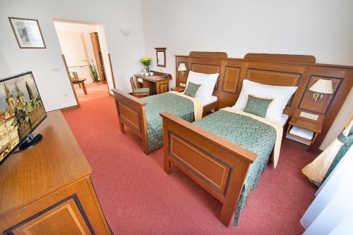 a hotel room with two beds and a television at U Medvidku-Brewery Hotel in Prague