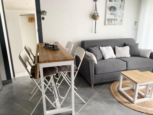 un salon avec une table et un canapé dans l'établissement Maison de Vacances Bassin d'Arcachon, à Gujan-Mestras
