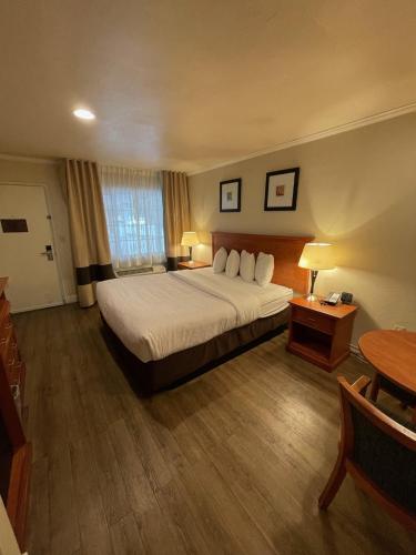 a hotel room with a bed and a table at Blu Pacific Hotel in Monterey