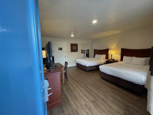 a hotel room with two beds and a television at Blu Pacific Hotel in Monterey