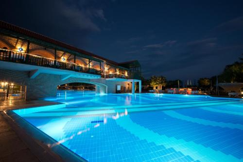a large swimming pool in front of a building at night at Limak Limra Hotel & Resort Kemer - Kids Concept in Kemer