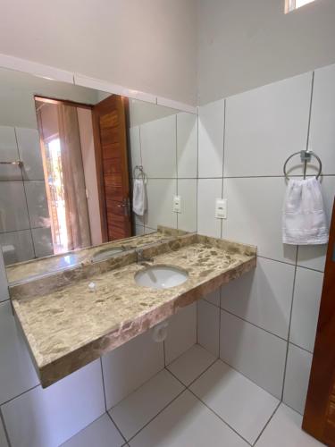 een badkamer met een wastafel en een spiegel bij Pousada Carmela in Icapuí