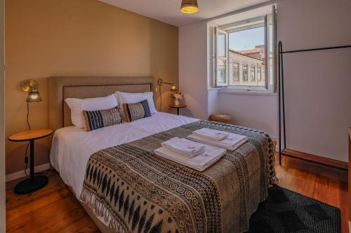 a bedroom with a bed with two towels on it at Chiado Premium Two Bedroom Apartment by Les Deux Mariettes in Lisbon