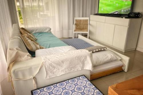 a living room with a couch and a television at Green Park 2 Ambientes en PB con Jardín y Parrillero in Punta del Este