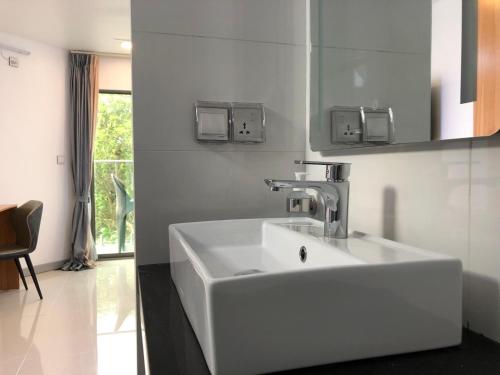 ein Badezimmer mit einem weißen Waschbecken und einem Spiegel in der Unterkunft Wow Inn Keyodhoo in Felidhoo 