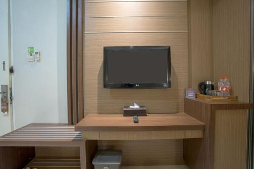 a room with a flat screen tv on a wall at Life Emerald Hotel Surabaya in Surabaya