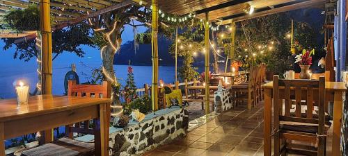 a restaurant with tables and a view of the water at Hotel & Restaurante Arca de Noé in Santa Cruz La Laguna
