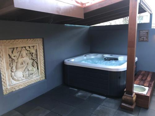 a jacuzzi tub with a statue in a bathroom at Bali at the Bay in Nelson Bay