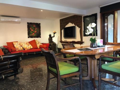 a living room with a red couch and a table at Bali at the Bay in Nelson Bay