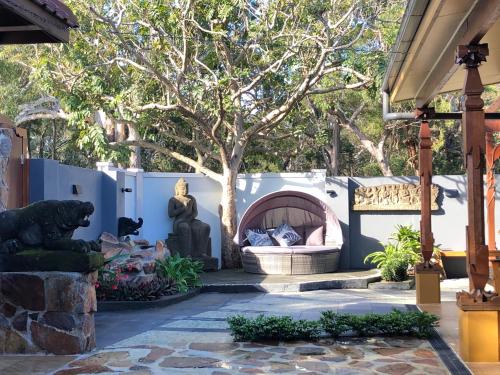 een patio met een vuurplaats en een boom bij Bali at the Bay in Nelson Bay
