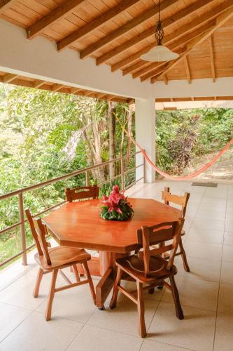 a wooden table and chairs on a porch with a view at Argovia Ecolodge in Tapachula