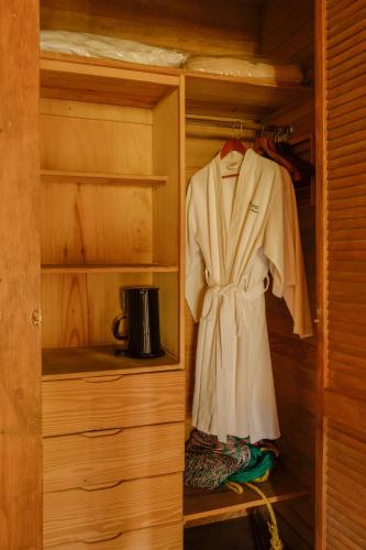 a robe is hanging in a wooden closet at Argovia Ecolodge in Tapachula