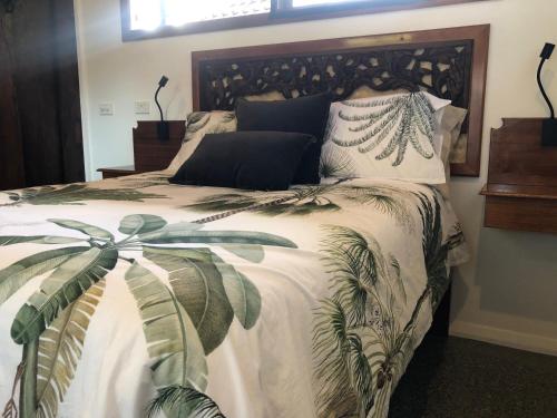 a bedroom with a large bed with a plant on it at Bali at the Bay in Nelson Bay