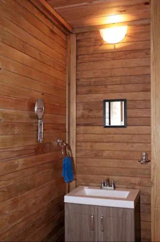 a bathroom with a sink and a wooden wall at Aldea Suncunu playa y alberca privada en Tuxpan in Tuxpan de Rodríguez Cano