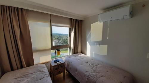 Habitación de hotel con 2 camas y ventana en Vista Infinita, en Punta del Este