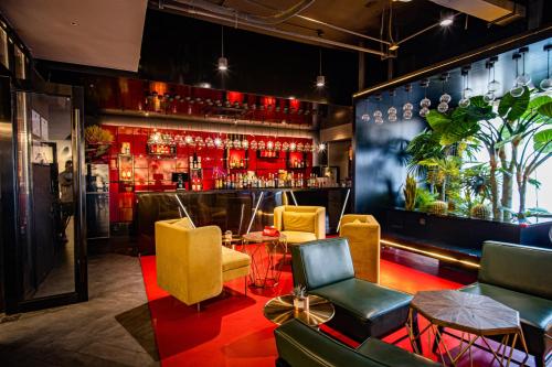 a bar with yellow and red chairs and a counter at SOON DESIGNER HOTEL Xi'an Drum Tower & YONGNING Gate Branch in Xi'an