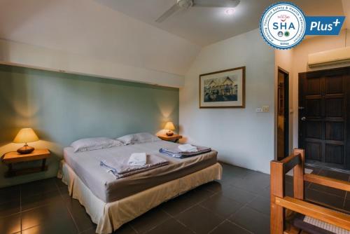 een slaapkamer met een bed en een bord met shka plus bij Phuket Campground in Mai Khao Beach