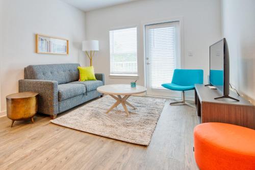 a living room with a couch and a tv at Luxe One Bedroom Apartment with Balcony in Gainesville